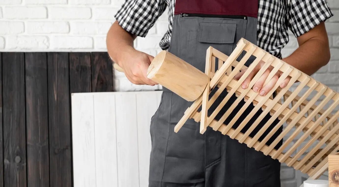 Nahaufnahme eines Mannes, der an einem Holzobjekt arbeitet.